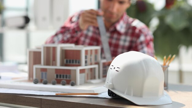 建築家の背景にテーブルの上に建設ヘルメット