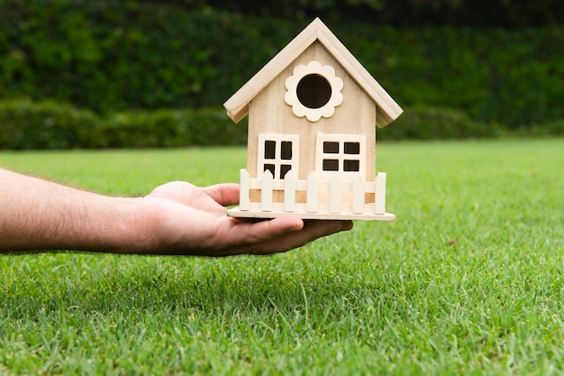 Construction house concepts hand holding a wooden miniature home hand holds toy house