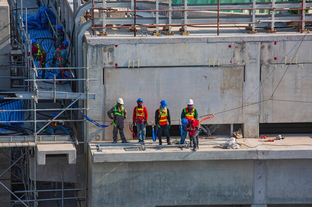 Construction industry engineer foreman standing orders for worker team to work at high safety