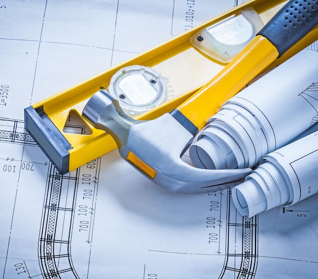 Construction level claw hammer and rolls of blueprints maintenance concept