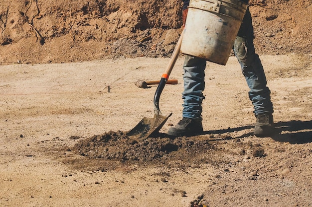 Foto uomo della costruzione che fa miscela di cemento al cantiere