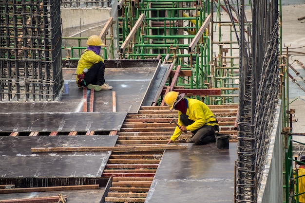 Lavoratori dell'uomo della costruzione che lavorano al cantiere