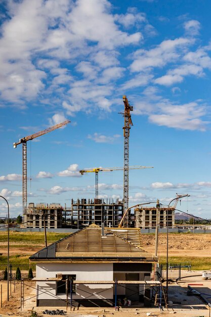 Costruzione di una casa monolitica in cemento armato sullo sfondo di un cielo nuvoloso. gru a torre. tecnologie costruttive. costruzione di un moderno edificio multipiano.