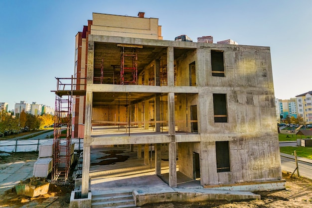 Construction of a monolithic reinforced concrete house closeup\
of a building under construction the sun\'s rays illuminate the\
construction site shooting from a drone modern building in the\
city