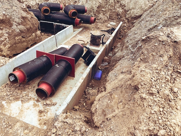 Construction of a new neighborhood laying communications pipes on the ground wide black