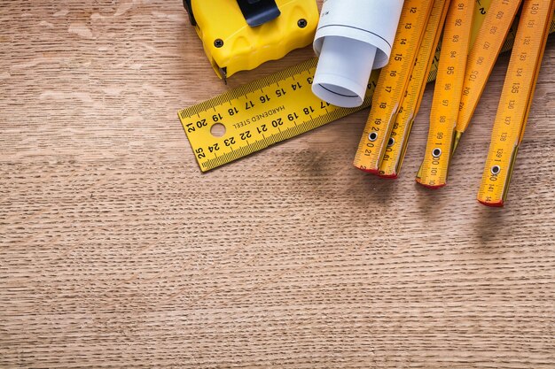 Construction plans and instruments of measurement on oaken wooden board maintenance concept