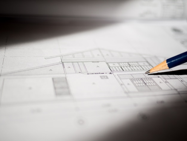 Photo construction plans and pencil for drawing on blueprint with sunlight from windows