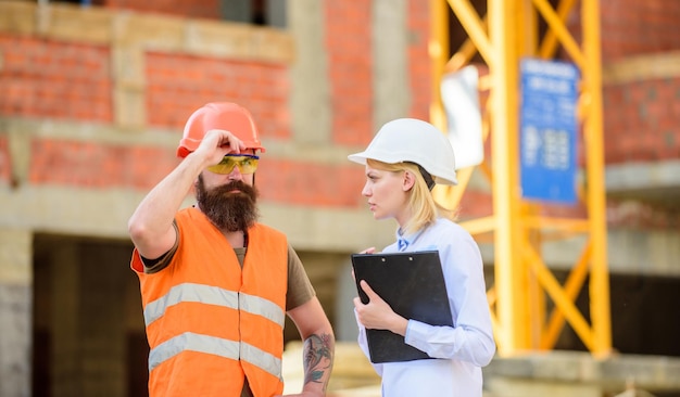 Construction project inspecting Construction inspection corrections and fines Discuss progress project Safety inspector concept Inspector and bearded brutal builder discuss construction progress