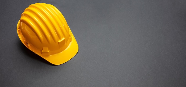 Construction project safety Yellow hard hat on black color background copy space