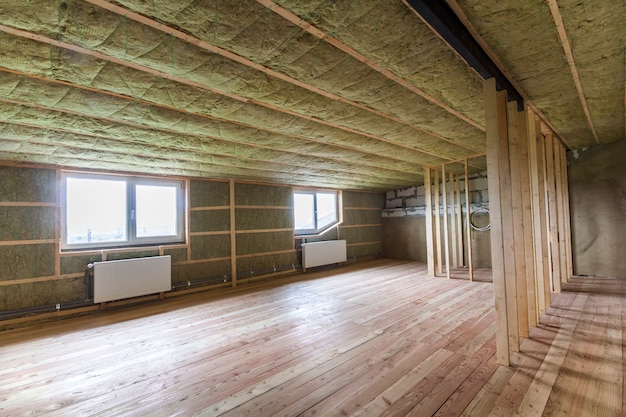 Construction and renovation of big light spacious empty room with oak floor, walls and ceiling insulated with rock wool