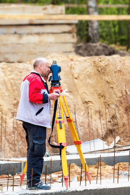 Photo construction of a residential area geodetic stakeout surveyor at a large construction site a man with a tachometer during work makshader