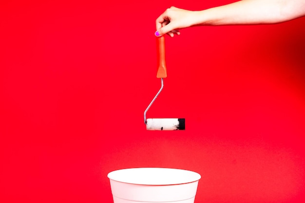 Construction roller is thrown into the trash on a red background