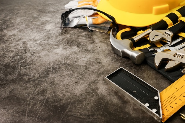 Construction safety equipment and tools on concrete texture background. 