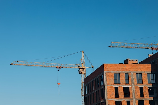 Construction site background hoisting cranes and new buildings\
industrial background