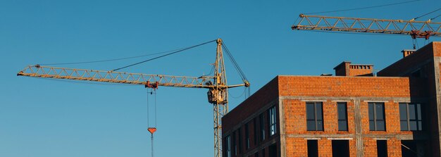 建設現場の背景ホイストクレーンと新しい建物産業の背景