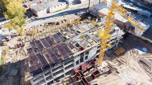 Construction site background. Hoisting cranes and new multi-storey buildings. Industrial background