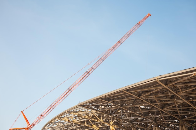 Photo construction site construction cranes and a building under construction against a blue sky