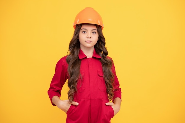 On construction site improve your childhood future engineer making repairs teen girl in protective hard hat child wear helmet for building protection and safety kid education concept