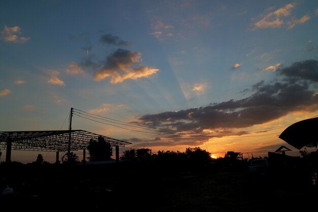 Construction site silhouetted against evening sky 