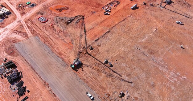 Construction site truck mounted pump pumping concrete sweat earth under vertical pilings drilling so