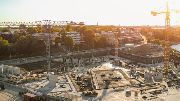 A construction site with a crane in the foreground and a city in the background.