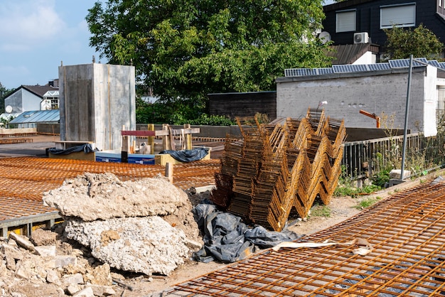 기초 의 건설 을 위해 준비 된 강화물 을 가진 건설 현장 앞면 에 있는 부서진 콘크리트 블록