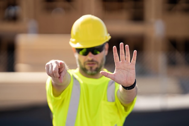 Foto operaio del cantiere in casco che lavora all'aperto un costruttore in un elmetto di sicurezza alla costruzione di bu