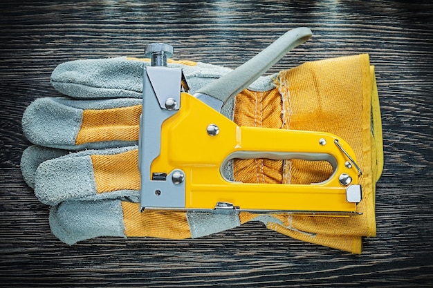 Foto coppia di guanti di sicurezza con pistola per graffette da costruzione