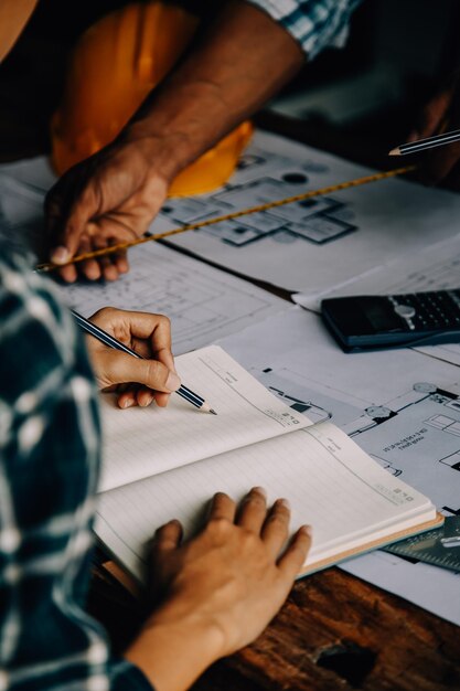 Foto concetto di costruzione e struttura dell'ingegnere che lavora disegno su progetto riunione per il progetto lavoro con il partner sulla costruzione di modelli e strumenti ingegneristici nel concetto di costruzione del sito di lavoro