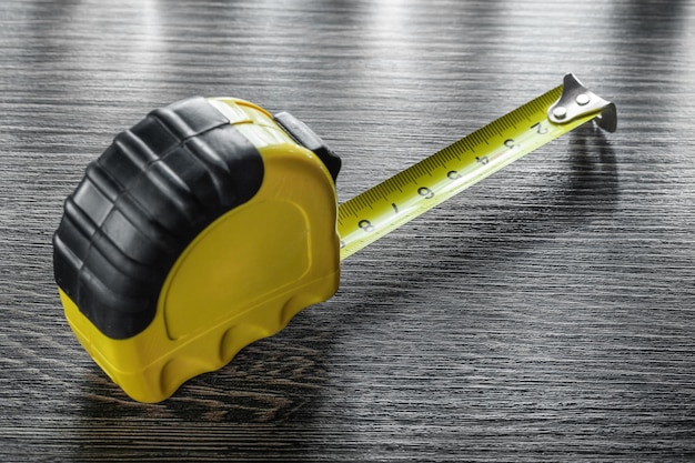 Construction tape measure on wooden board