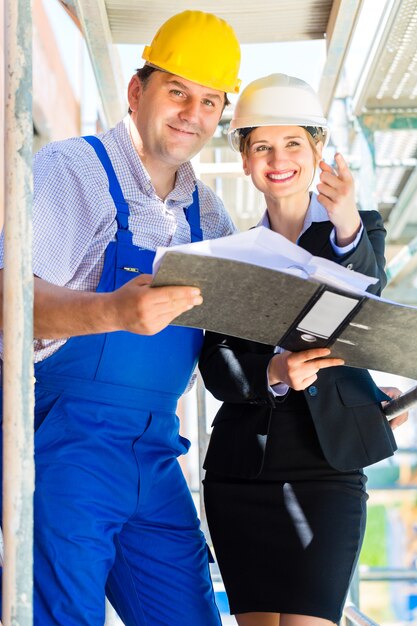 Team di costruzione con piani di costruzione in loco