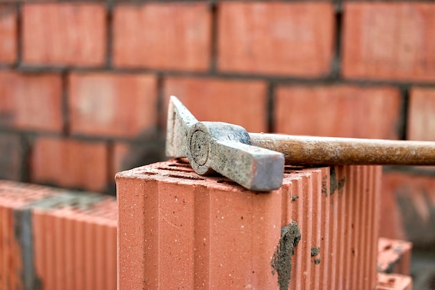 사진 벽돌과 블록을 깔기 위한 건설 도구 벽돌공의 도구 망치 주걱 흙손 장갑 brickwork의 배경에 손 도구