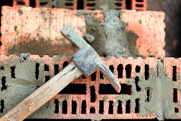 レンガやブロックを敷設するための作図ツール 職人の道具 ハンマーへら こて手袋 レンガ造りの背景にハンドツール