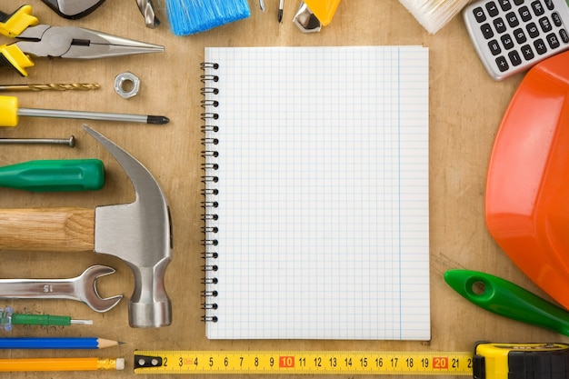 Construction tools and notebook on wood texture