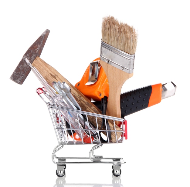 Construction tools in shopping cart on white