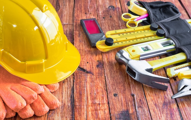 Construction tools in toolbelt on wooden background