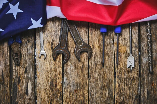 Строительные инструменты и флаг США на деревянном фонеКонцепция Дня труда первого мая