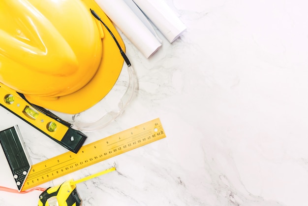 Construction tools with helmet safety on white marble background