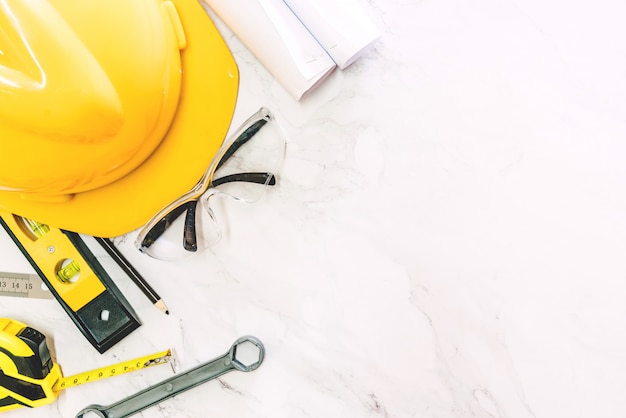 Construction tools with helmet safety on white marble background