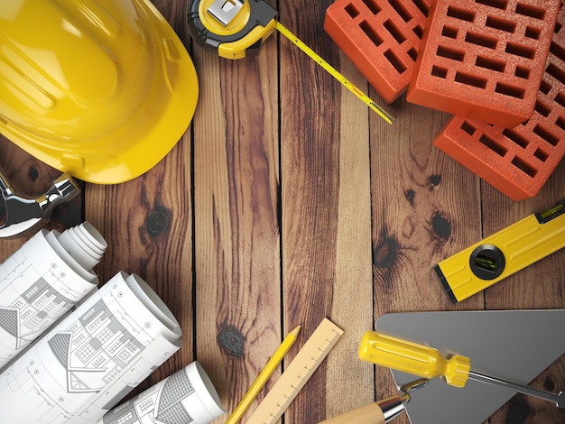 Construction tools on a wooden background Hard helmet bricks trowel drawing and level with space for text