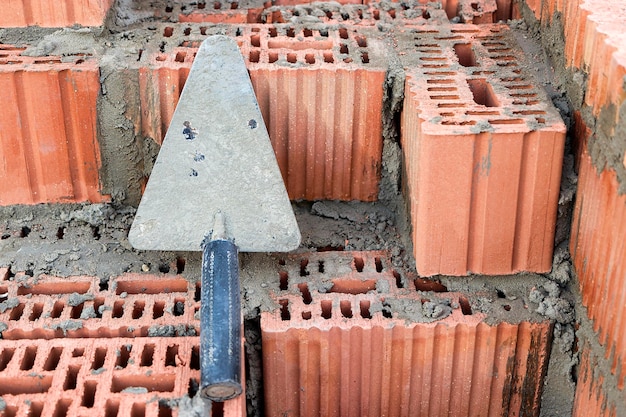 Construction trowel for laying bricks and blocks Construction tool of a bricklayer Hand working tool on the background of brickwork