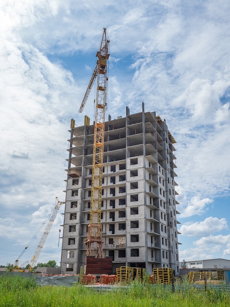 Construction work site and high rise building. High-rise building under construction. Reinforced concrete frame. Vertical view.