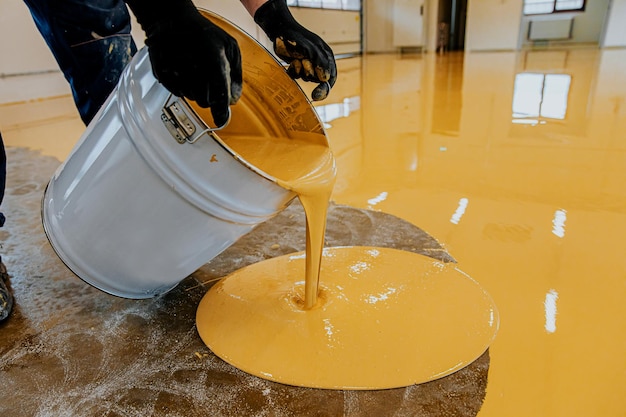 Photo a construction worker apply epoxy resin in an industrial hall