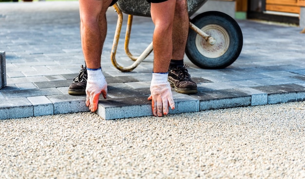 道路の舗装石を並べている建設作業員