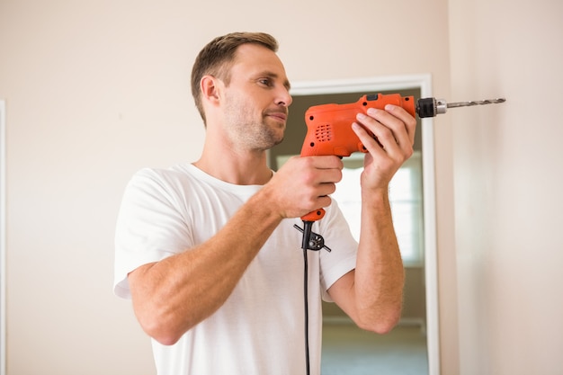 Construction worker drilling hole in wall