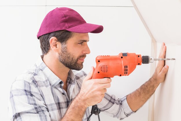 Construction worker drilling hole in wall