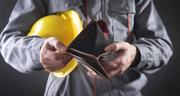 Construction worker holding empty wallet.