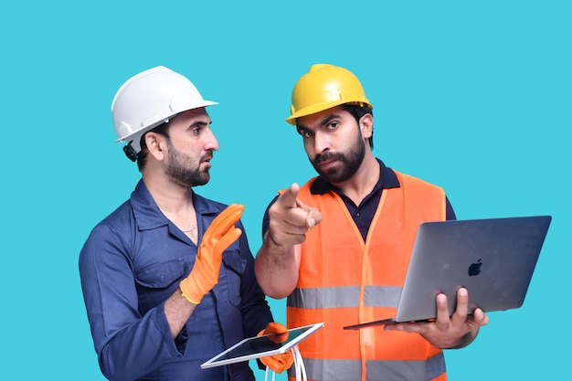 construction worker holding laptop and pointing front indian pakistani model