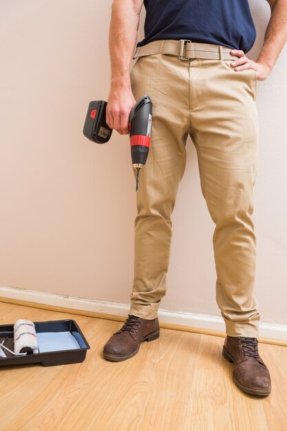 Construction worker holding power tool