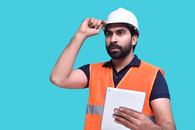 construction worker holding tab and looking away indian pakistani model